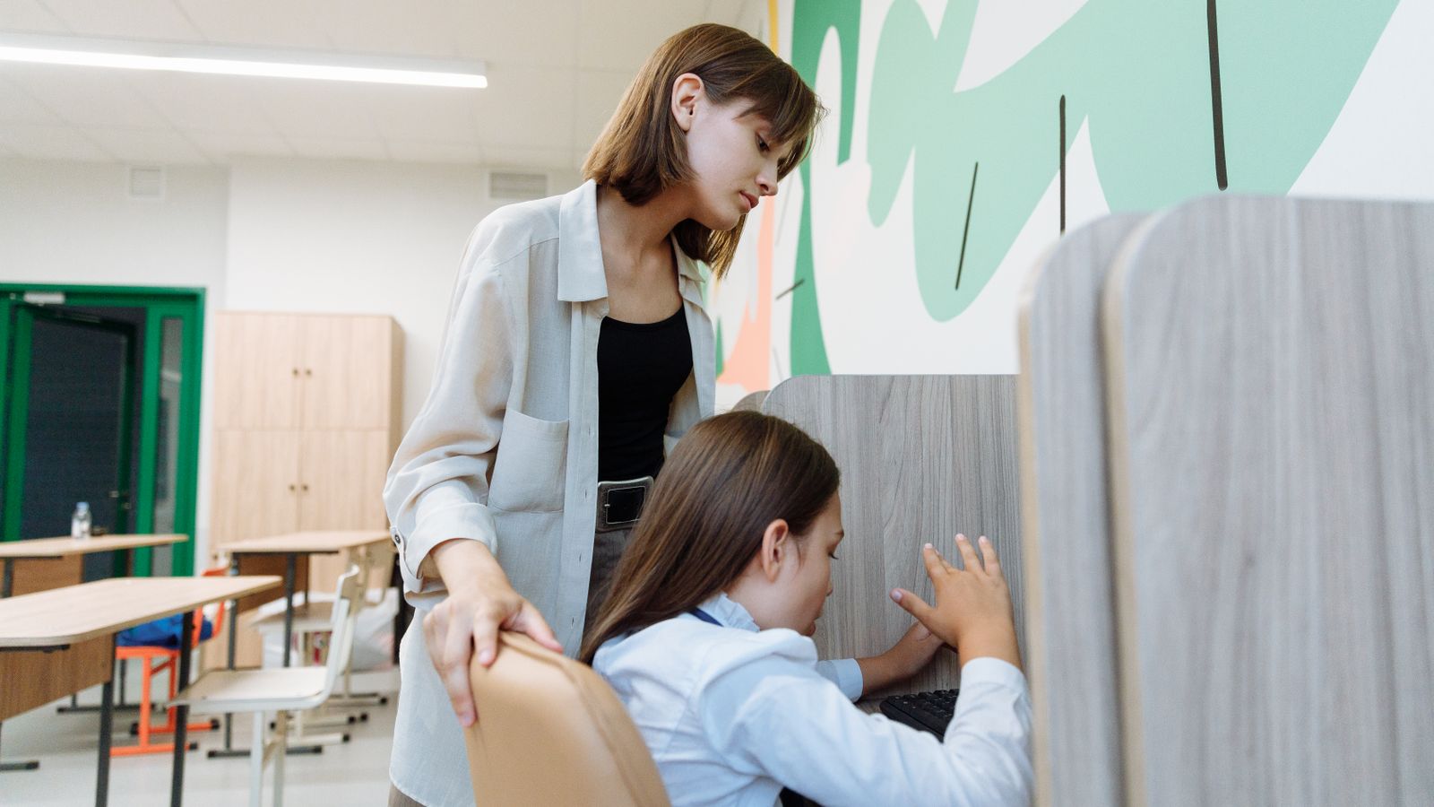A teacher attentively helping a student with their work